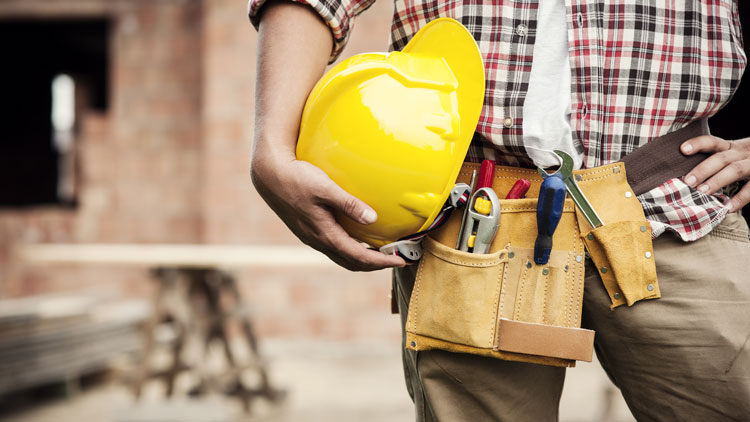 Handwerker mit Werkzeuggürtel und Helm in einem Hausrohbau; Copyright Panthermedia